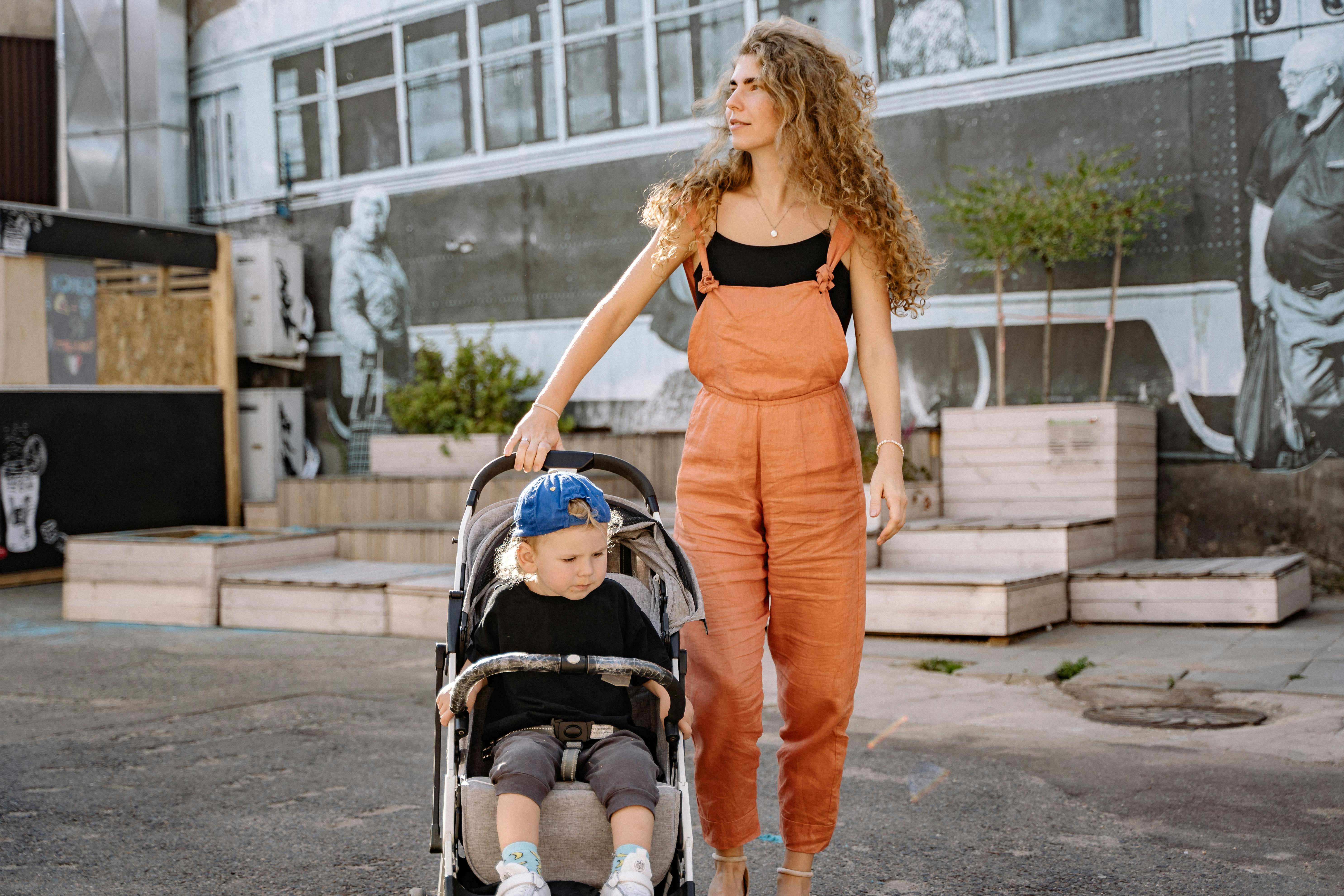 woman in dungarees with child in a pram