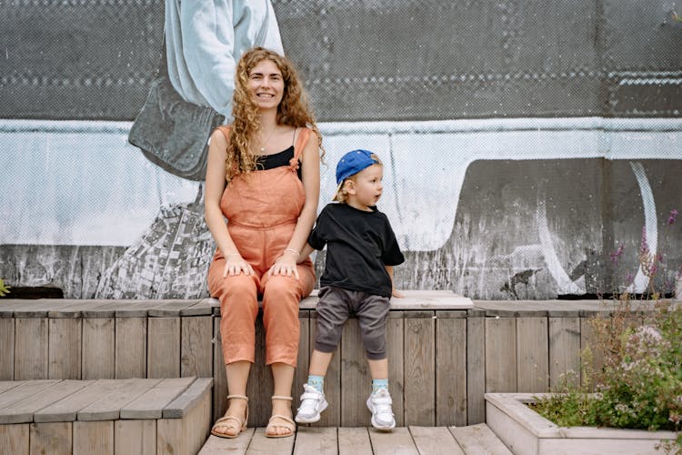 Happy Woman And Child Sitting On Bench Outside