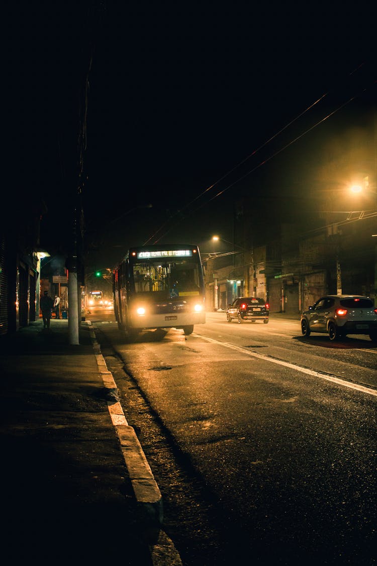 Bus Driving On Road At Night