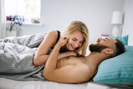 一对快乐的情侣在舒适的卧室里欢笑、亲密，传递着温暖和爱