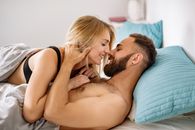 Man in Blue Tank Top Kissing Woman in White Tank Top