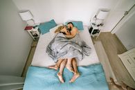 Woman in Gray Dress Lying on Bed