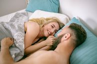 Woman Lying on Bed With Man on Her Back