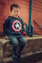 Cute boy sitting on stone border