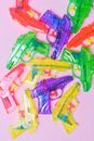 Colored pistols made of plastic on pink background