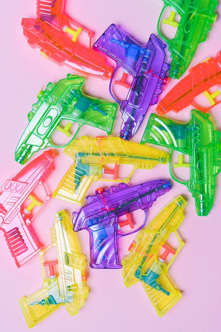 Colored Pistols Made Of Plastic On Pink Background