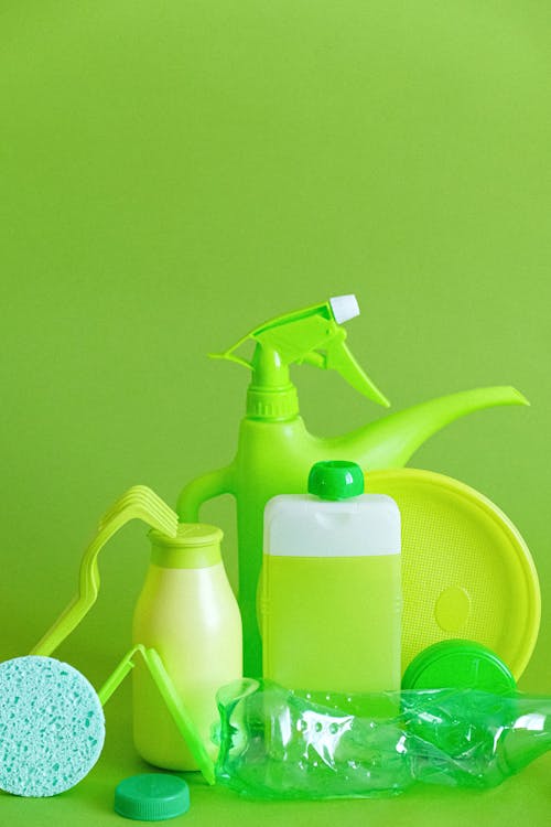 Green detergent bottle with sprayer and sponge with plate
