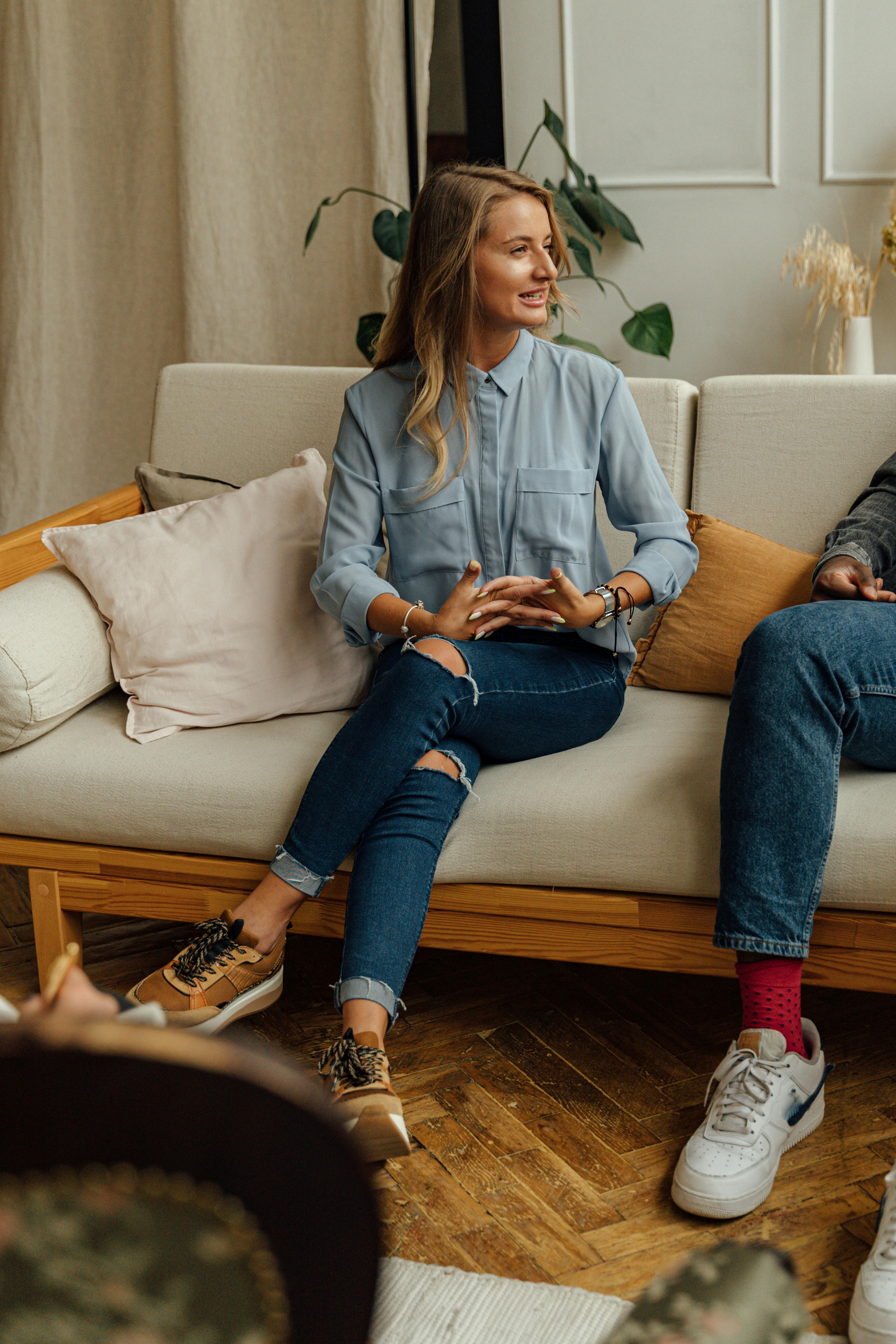 a woman in blue long sleeves sitting on the sofa