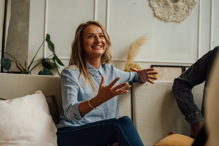 A Smiling Woman Sitting On A Couch