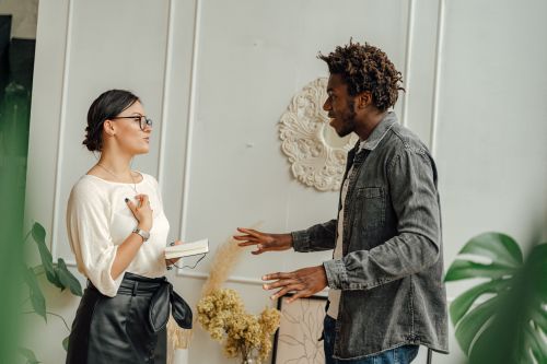 Free Two adults engaging in a friendly conversation indoors, sharing ideas. Stock Photo