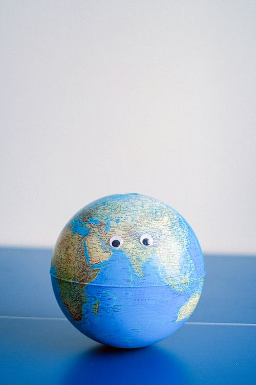 Free Sphere shaped miniature of Earth with googly eyes Stock Photo