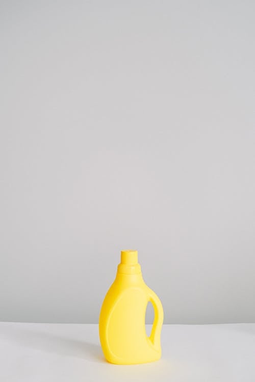 Free Yellow plastic bottle with antibacterial chemical liquid for household routine placed on table isolated on white background in light room Stock Photo