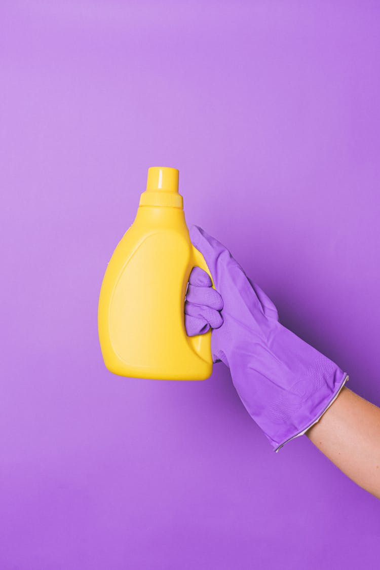 Crop Person With Yellow Bottle With Detergent