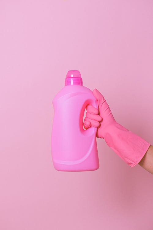 Crop housekeeper with pink bottle of cleaner