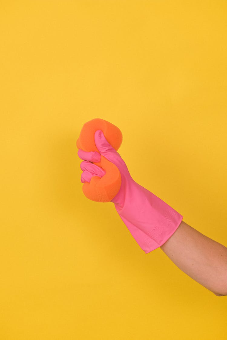 Crop Faceless Person In Rubber Glove Squeezing Sponge