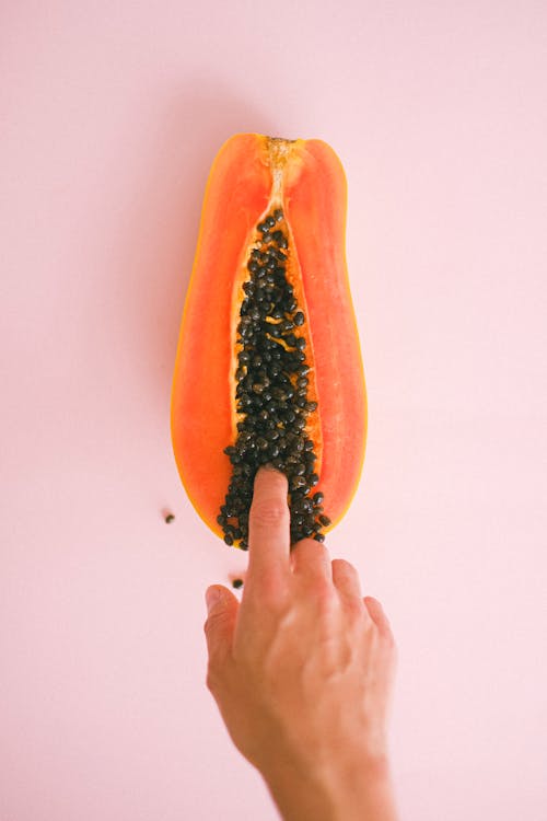 Free Crop faceless woman touching cut sweet papaya Stock Photo