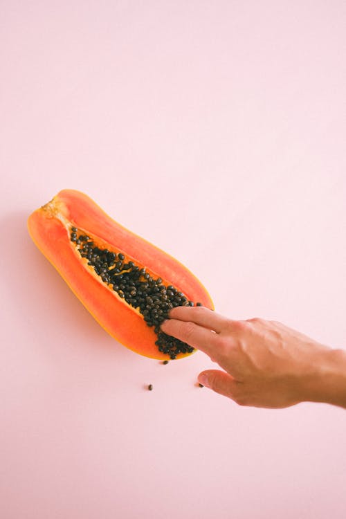 Free Crop unrecognizable woman touching ripe cut papaya Stock Photo