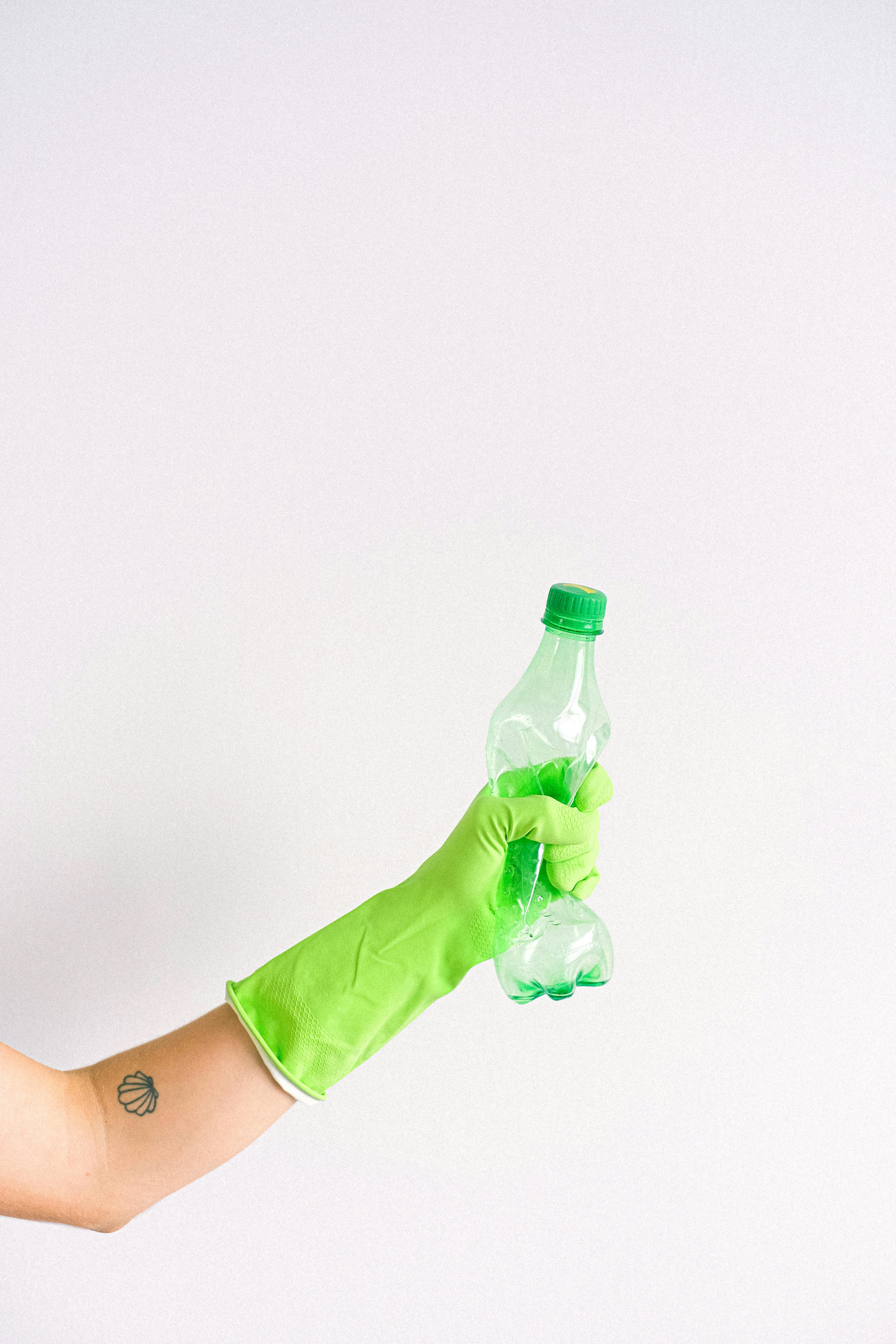 woman in gloves squeezing plastic bottle