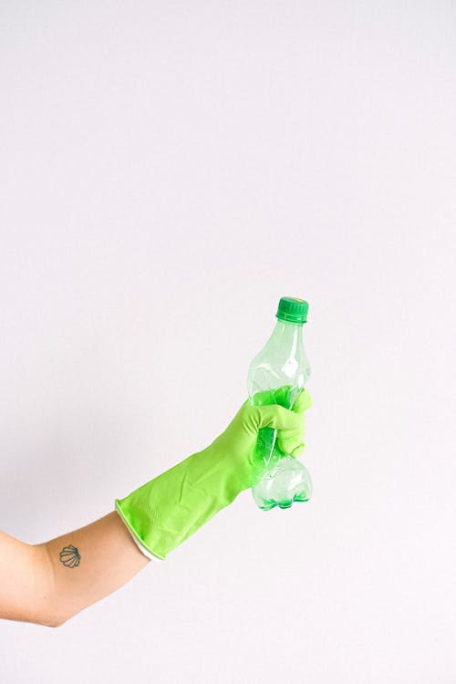 Woman in gloves squeezing plastic bottle