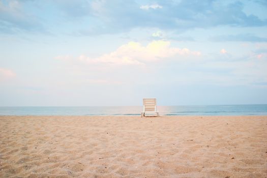 Empty sandy beach with lonely plastic sunbed located near calm sea at daytime