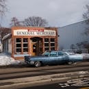 Blue Sedan Parked in Front of a Store