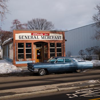 Classic blue car outside a vintage store with winter setting, perfect for nostalgic themes.