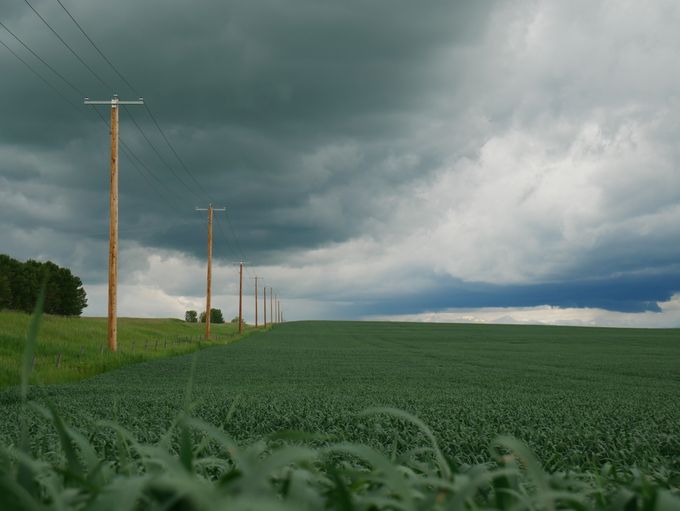 Storm clouds over open fields and power lines, photo by Quinn Petersen on Pexels