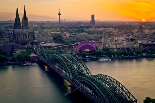 Free Stunning aerial view of Cologne featuring Hohenzollern Bridge and Cathedral at sunset. Stock Photo