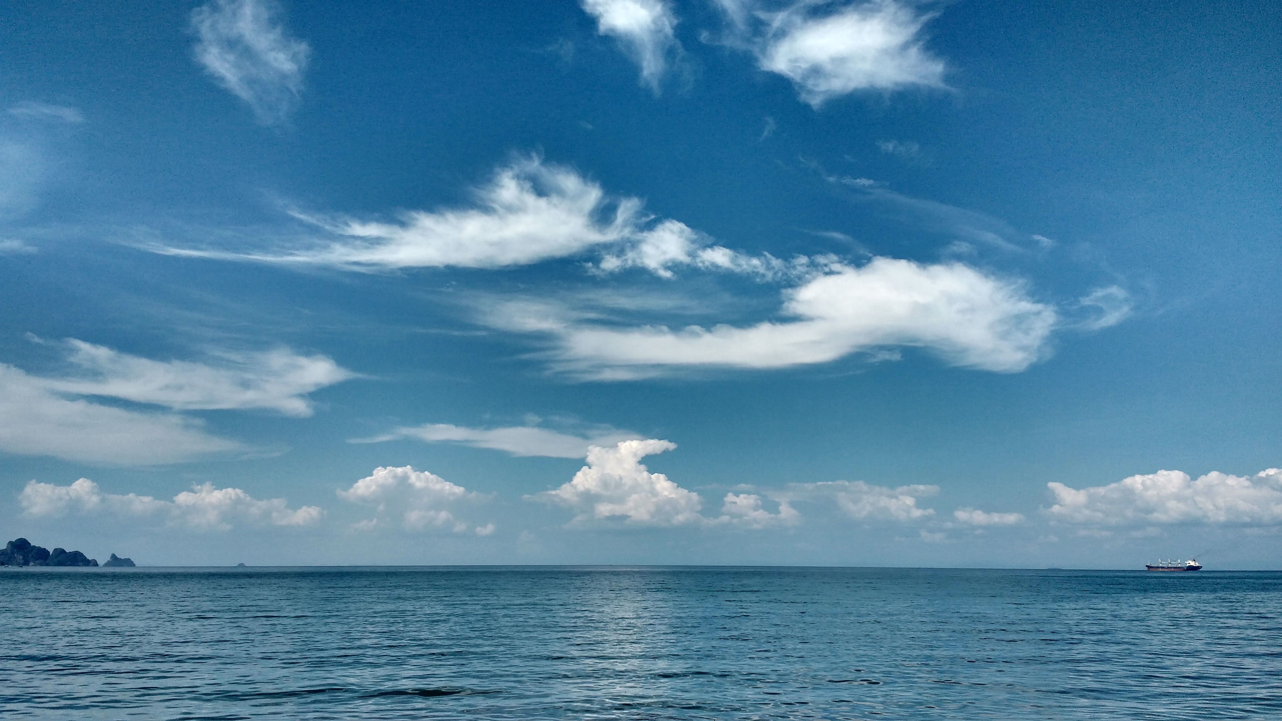 Peaceful ocean view in Langkawi, Kedah, Malaysia with blue skies and clouds.