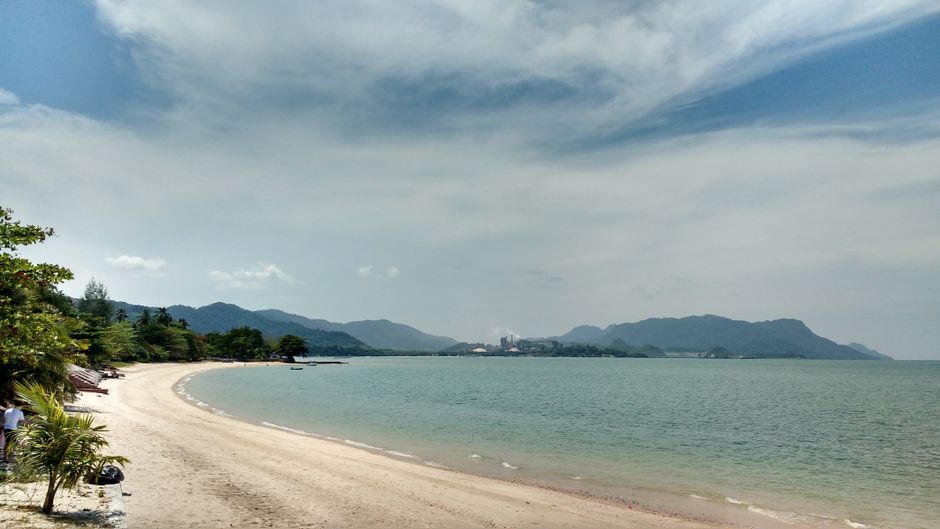 Ferry approaching Kuah Jetty in Langkawi, Malaysia, with lush green hills in the background.