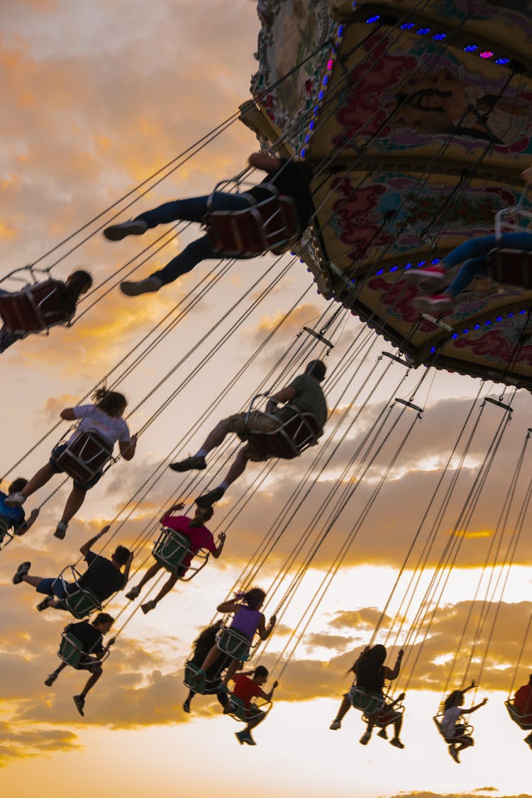 People Riding Chain Carousel In Amusement Park