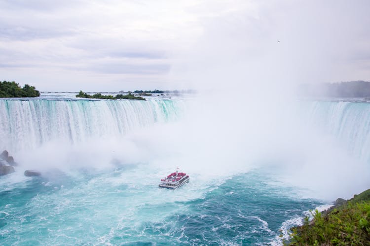 Splashing Niagara Falls And Yacht Sailing On River