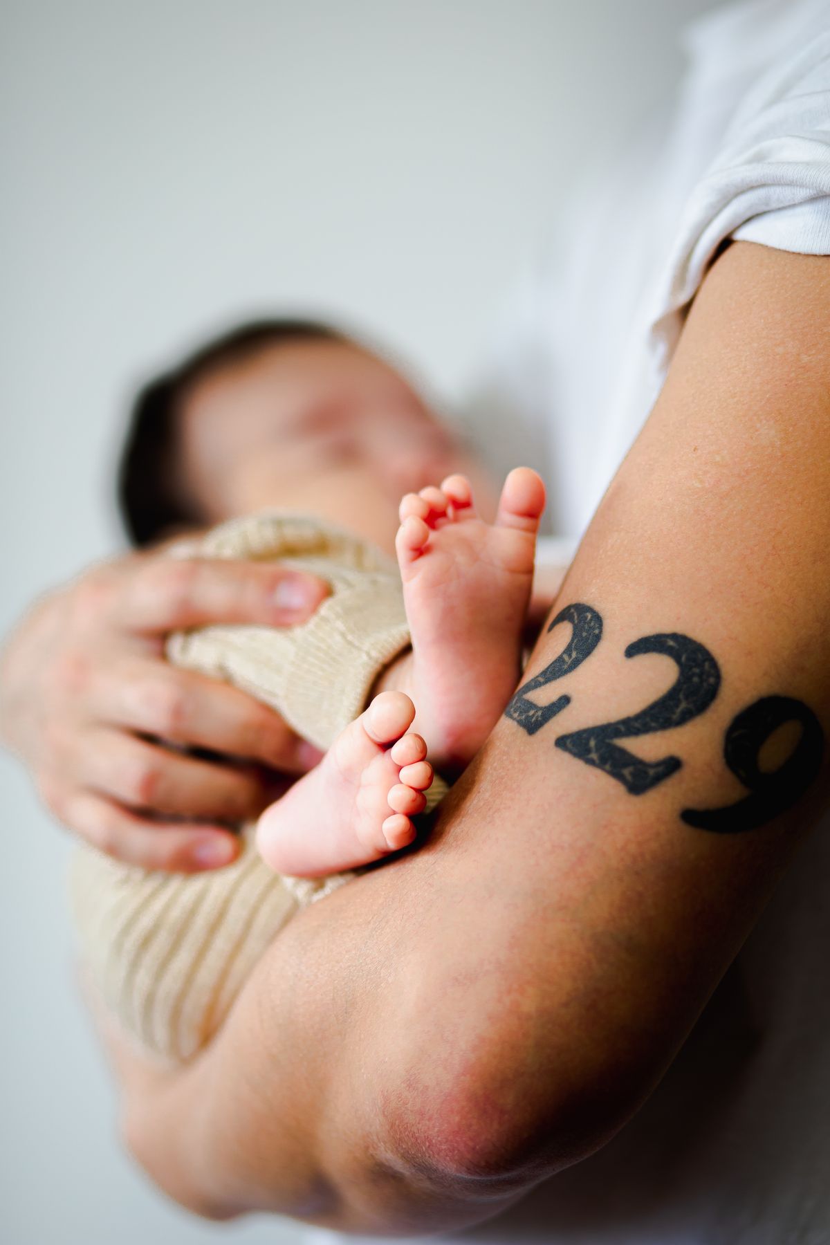 Parent gently holding a sleeping newborn baby in a calm home setting
