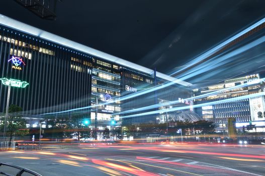 Dynamic night cityscape of Fukuoka, Japan featuring vibrant light trails and modern architecture.