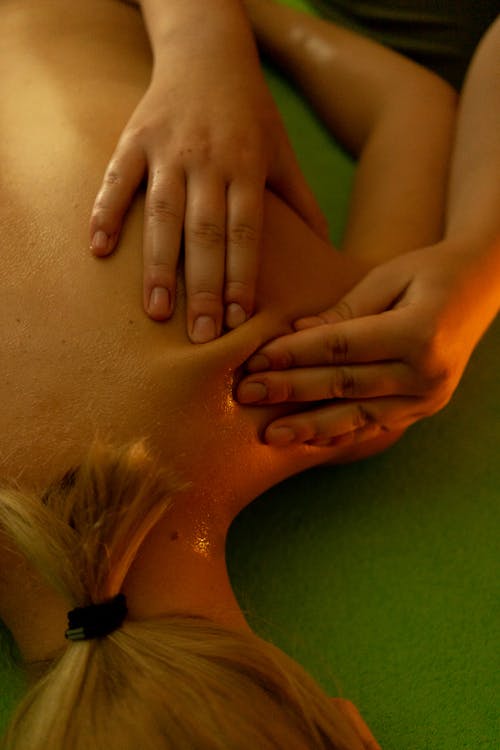 Free From above of anonymous slim female with short hair lying on stomach and resting during massage session Stock Photo