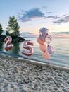 Two Brown and White Heart Shaped Balloons on Beach Shore