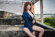 Woman in Blue Long Sleeve Dress Sitting on Concrete Bench