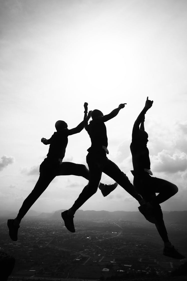 People Jumping Over City In Cloudy Weather