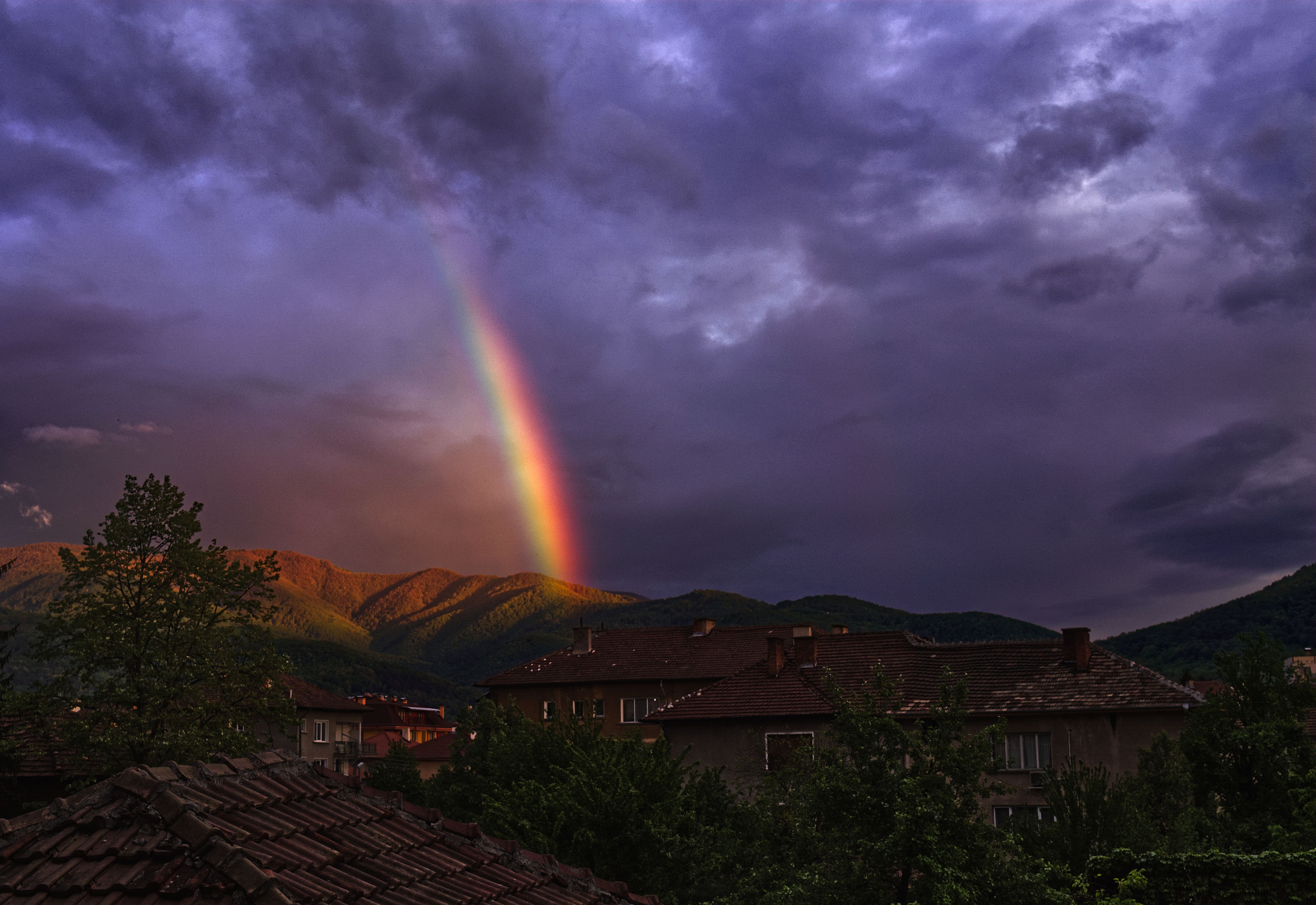 黄昏时分，保加利亚博特夫格勒上空暴风雨云弥漫，一道充满活力的彩虹划出弧线