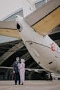 Man in Gray Jacket Standing Beside White Airplane