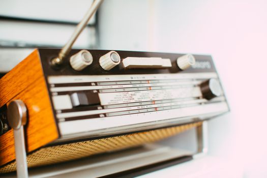 Close-up of a classic vintage radio with wooden finish and tuning knobs, showcasing retro elegance.