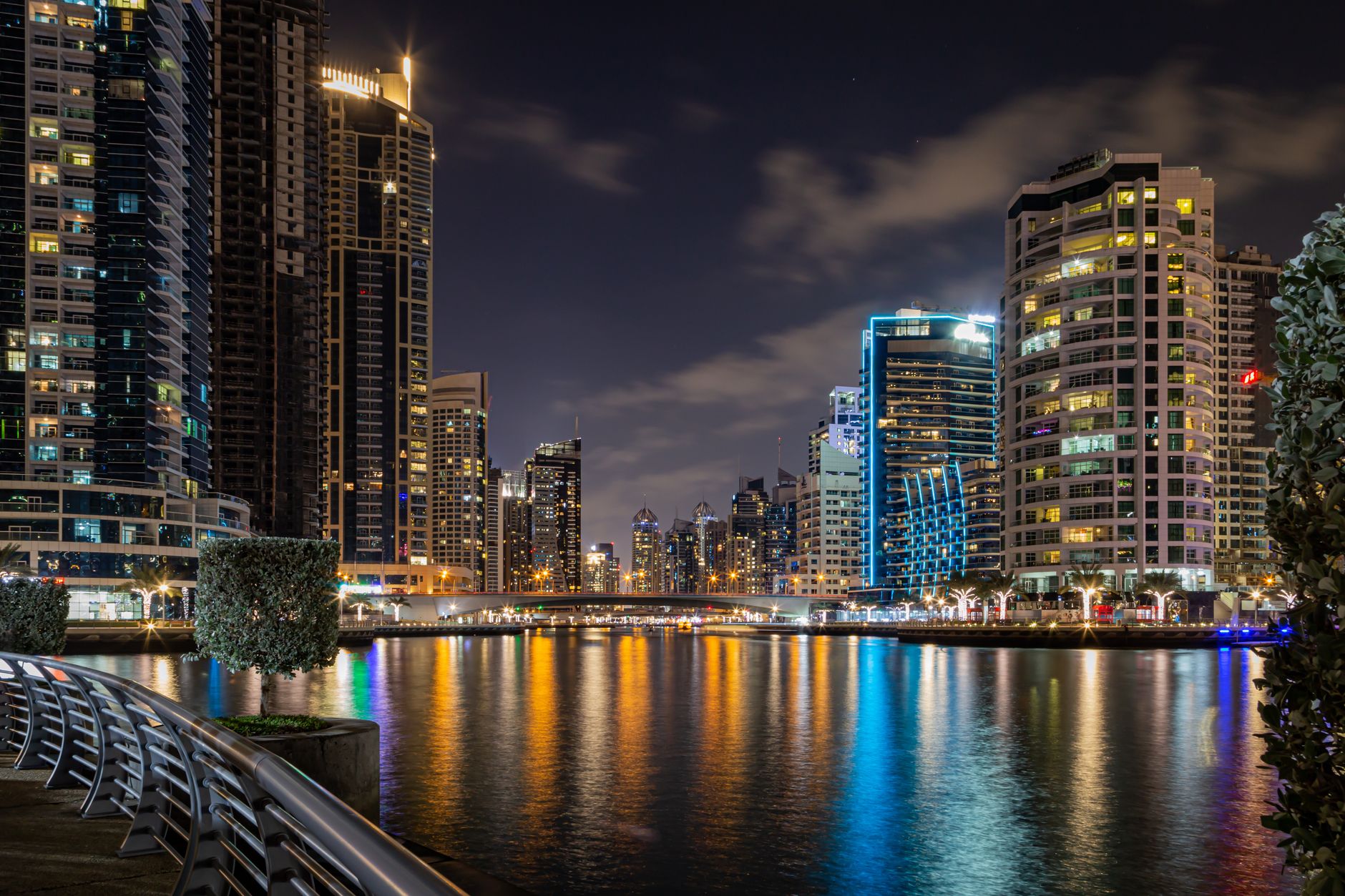 Stunning city skyline at night with lights reflecting on the water, showcasing modern architecture.