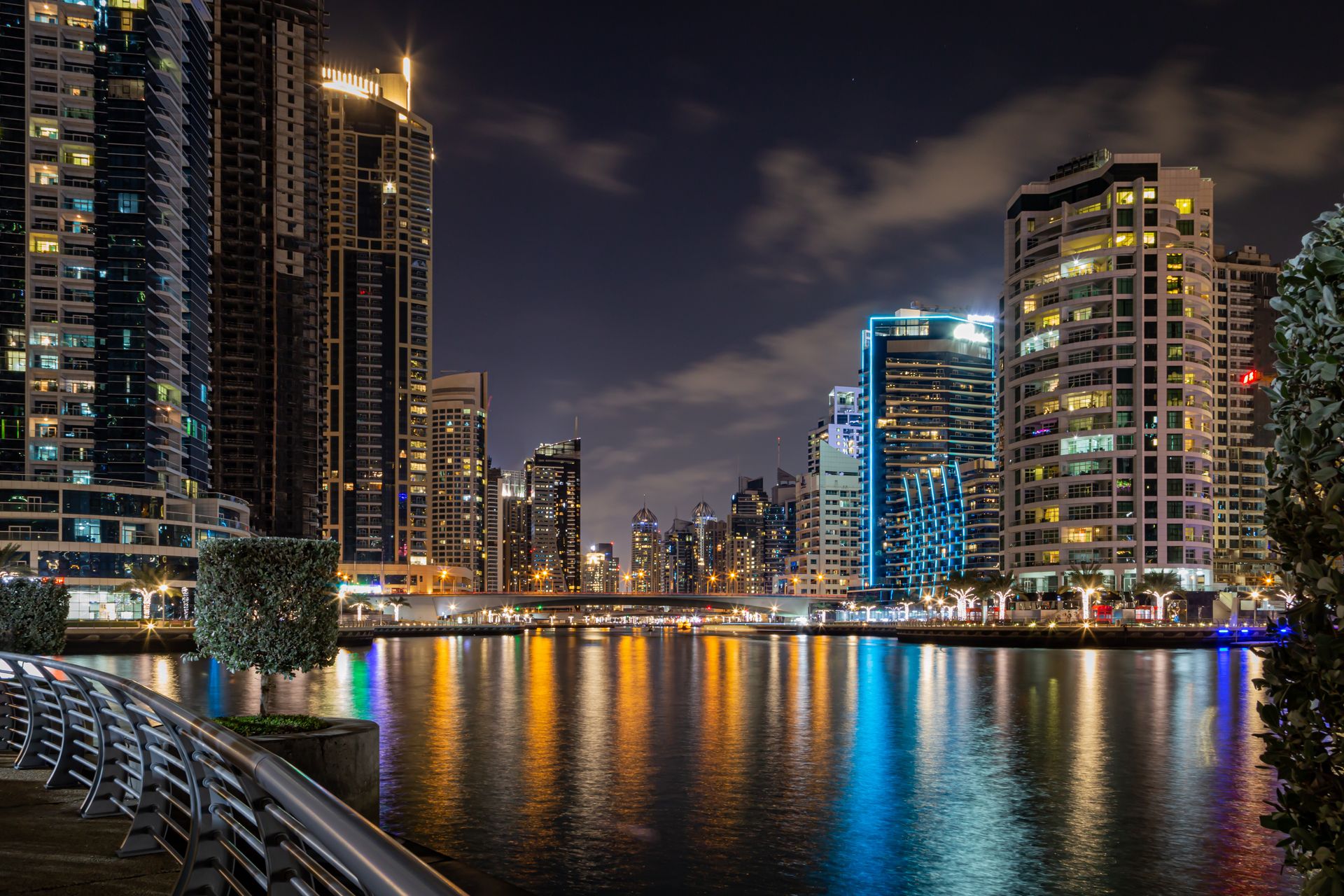 Stunning city skyline at night with lights reflecting on the water, showcasing modern architecture.