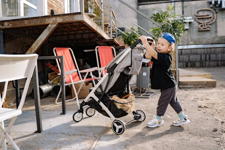 Child Pushing A Stroller 