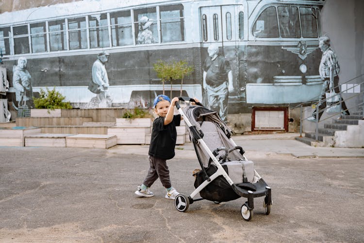 Boy Pushing Stroller On Street