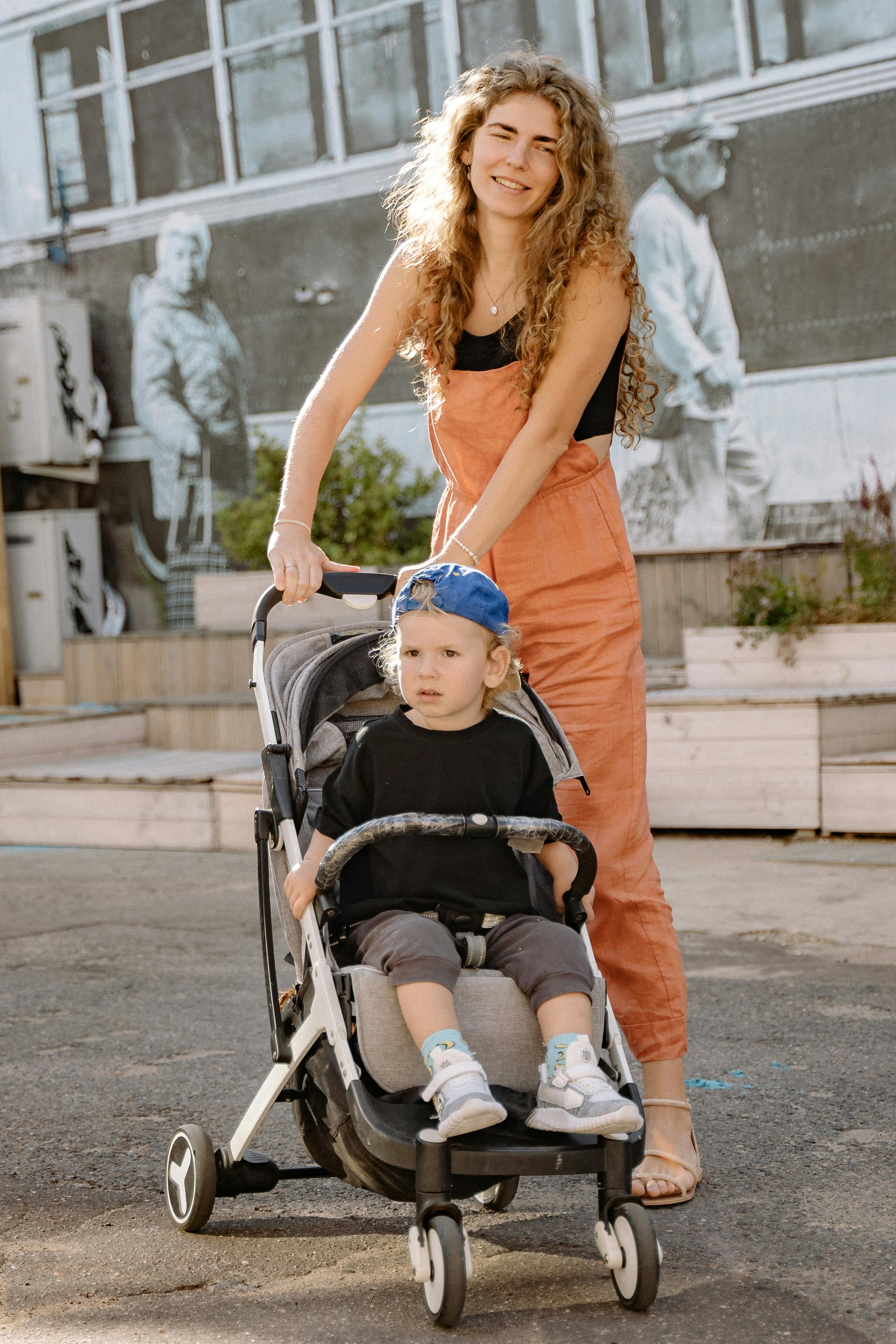 woman pushing a stroller with her son inside