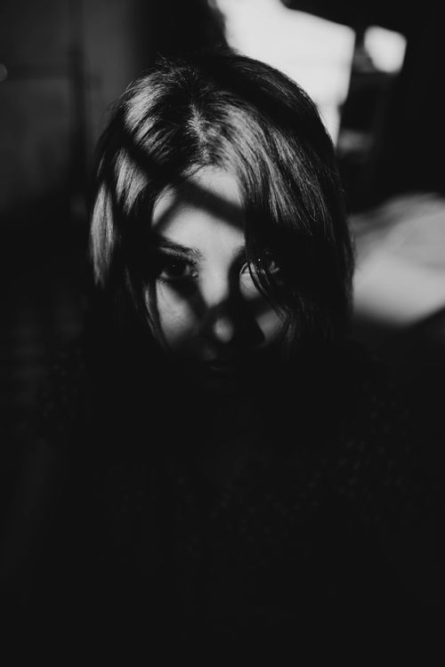Free A dramatic black and white portrait of a woman with shadow play on her face. Stock Photo
