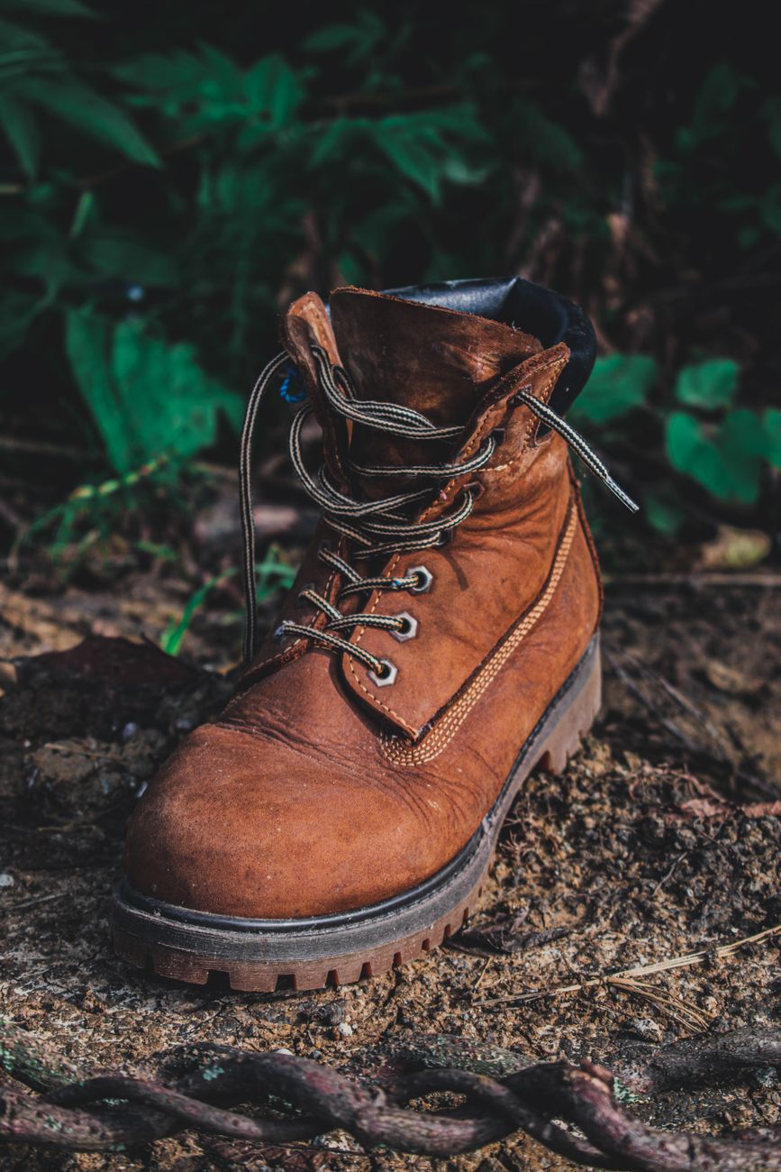 Wandelschoen met veters op bosgrond