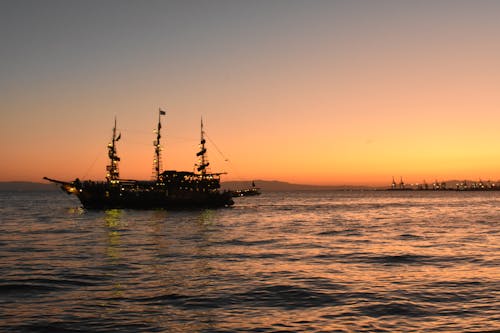 A Wooden Ship Sailing on the Sea Under Golden Sky