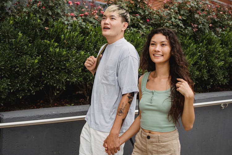 Cheerful Diverse Couple Walking On Street